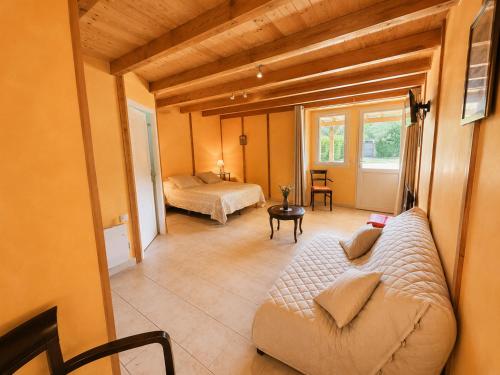 a living room with a couch and a bed at Chambres de l'Igues in Montfaucon