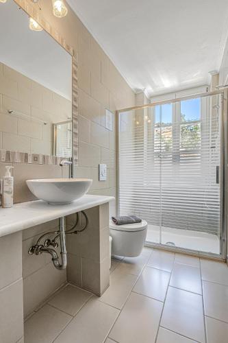 a bathroom with a sink and a toilet and a window at Greco Hotel in Hydra