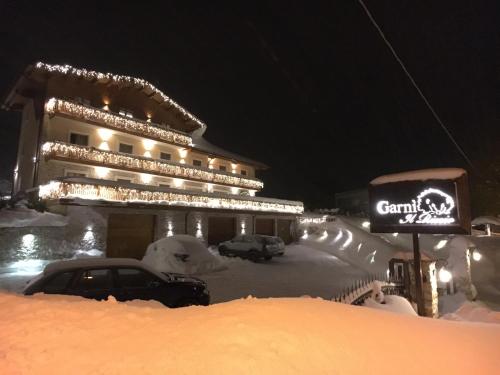 ein schneebedecktes Gebäude, in dem Autos vor der Tür geparkt sind in der Unterkunft Boutique Hotel Il Riccio - Adults Only in Roccaraso