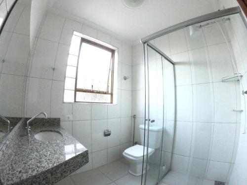 a bathroom with a toilet and a glass shower at Casa Alceste - Casa inteira, com garagem privativa, a 10 minutos a pé do Centro Histórico de Diamantina - 05 hóspedes in Diamantina