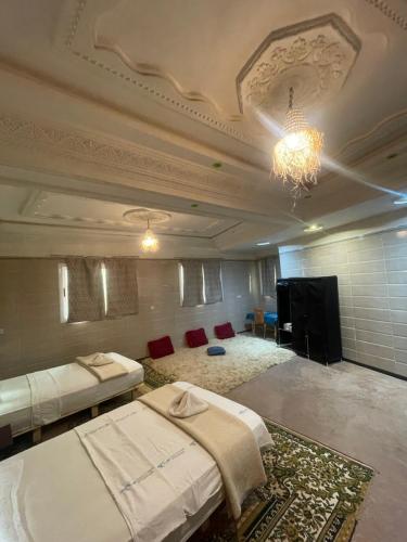 a large room with two beds and a television at Red Rocks Guest House in Tamellalt