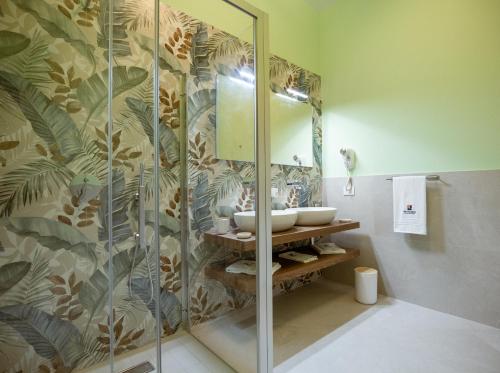 a bathroom with a glass shower with a sink at Monnalisa Rooms in San Vito lo Capo