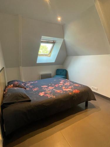 a small bedroom with a bed with a window at LE BRIDGE in Bénouville