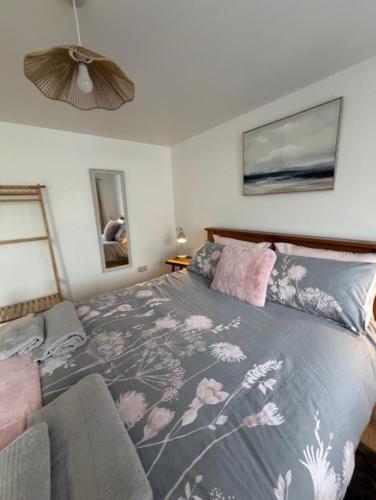 a bedroom with a bed with a floral bedspread at Pendragon Studio in Penzance