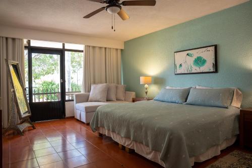 a bedroom with a bed and a chair and a window at Toca Madera in Chapala
