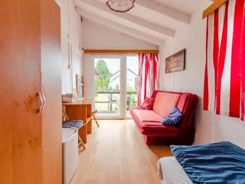 a living room with a red chair and a window at Osada Rybacka in Jastrzębia Góra