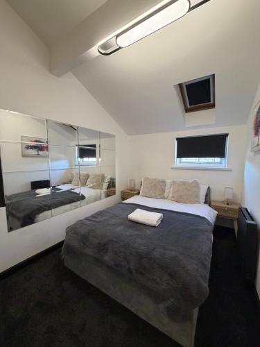 a bedroom with a large bed and a mirror at Glowstay 2 in Lampeter