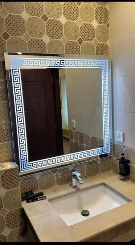 a bathroom with a sink and a large mirror at JAANI's Hotel in Bhattiawāla