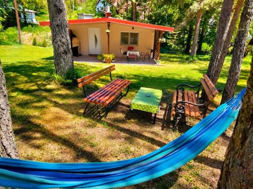 a blue hammock in a yard with a house at Vikendica Stari Grad in Divčibare