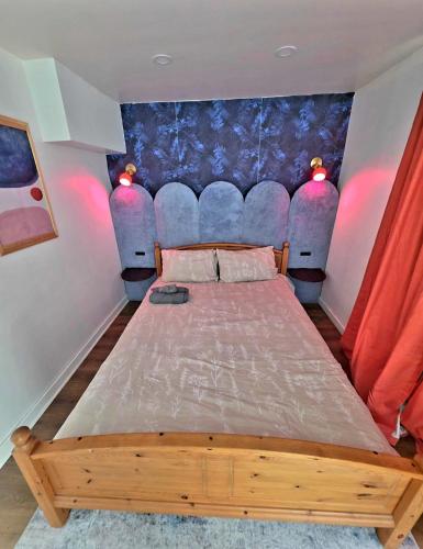 a bedroom with a bed with a blue head board at Respite room in Chambly