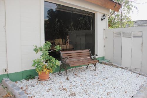 a bench sitting outside of a house with a window at Casa Calamo Hotel in Treinta y Tres