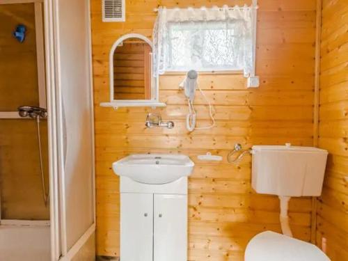 a wooden bathroom with a sink and a toilet at Osada Rybacka in Jastrzębia Góra