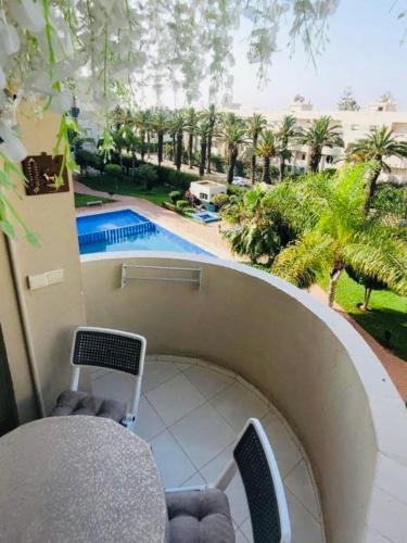 a balcony with a view of a swimming pool at The hidden oasis, steps from the beach and pool in Mohammedia