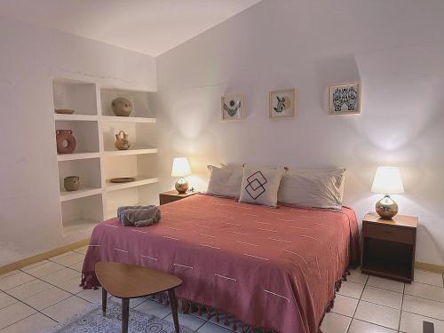 a bedroom with a bed and two lamps and shelves at Casa Ritual tu refugio con jardín & 4 recámaras in Oaxaca City