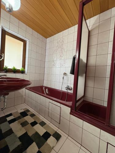 a bathroom with a red tub and a sink at Ferienwohnung Maxi in Pottenstein