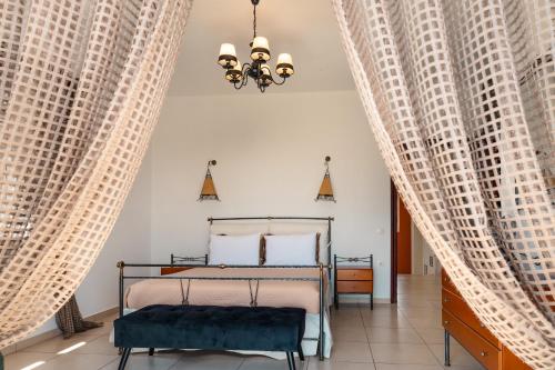 a bedroom with a bed and two large windows at Selenophile Villa with heated pool in Monolithos