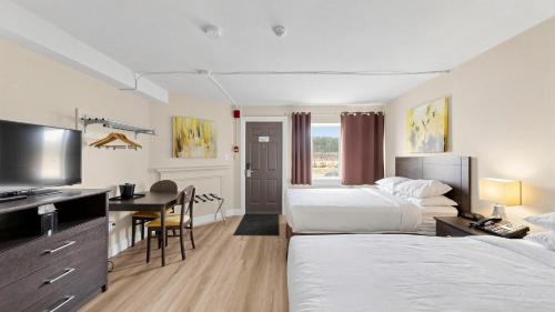 ein Hotelzimmer mit zwei Betten und einem Schreibtisch in der Unterkunft River Rapids Inn in Niagara Falls
