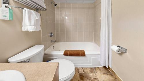 ein Badezimmer mit weißer Toilette und Badewanne in der Unterkunft River Rapids Inn in Niagara Falls