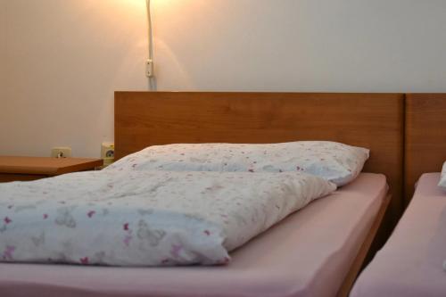 a bed with a white comforter and a wooden headboard at Villa Paris in Piešťany