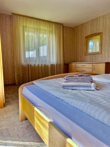 a bedroom with a large bed with blue sheets at The Yugo House in Bohinj