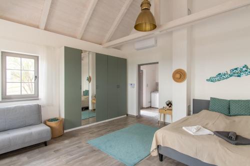 a bedroom with a bed and a couch and a living room at 1HA Tagyon Vendégház in Tagyon