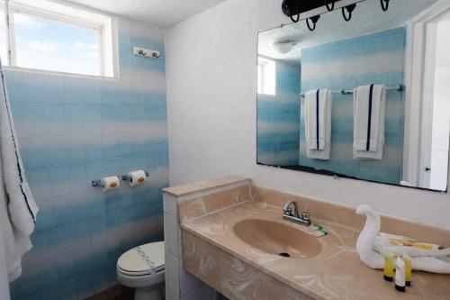 a bathroom with a sink and a toilet and a mirror at Playa Inn Rocky Point in Puerto Peñasco