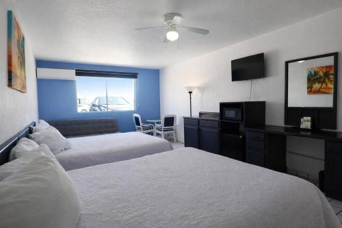 a hotel room with two beds and a television at Playa Inn Rocky Point in Puerto Peñasco