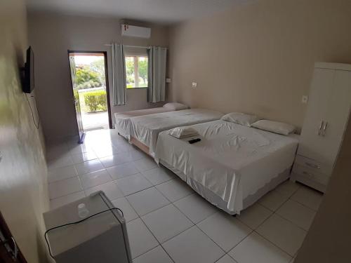 a bedroom with two beds and a window at Torre do Sol Park Hotel in Chapadinha