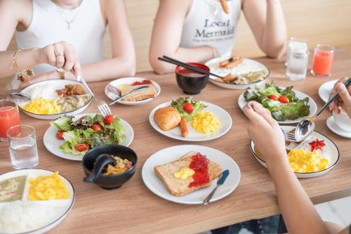 a group of people sitting at a table with plates of food at Manditel North Pattaya in North Pattaya