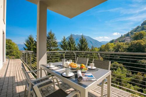 a table and chairs on a balcony with a view at Argegno Home in Argegno