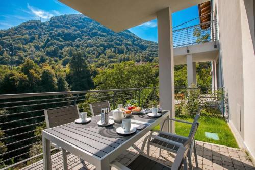 a table and chairs on a balcony with a view at Argegno Home in Argegno