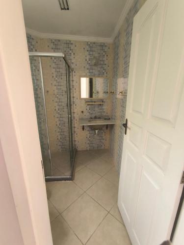 a bathroom with a shower and a glass door at "Cantinho das serestas" em flats com piscina, sem café in Conservatória