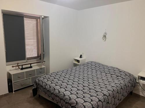 a bedroom with a bed and a window at F3 CENTRE de ST-FLORENT in Saint-Florent