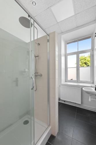 a bathroom with a glass shower and a sink at ZDZ Hostel Królewska 15 in Lublin
