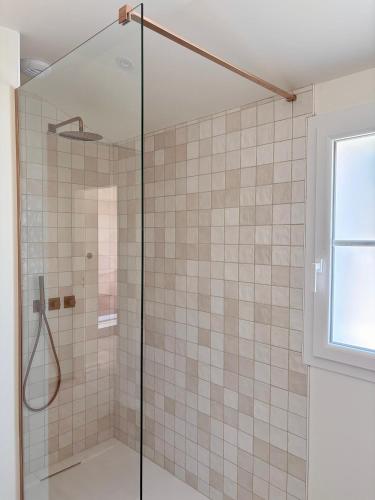 a bathroom with a shower with a glass door at Doudou House in Saint-Denis-dʼOléron