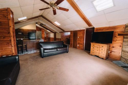 a living room with a couch and a ceiling fan at Riverside Motor Lodge - Pigeon Forge in Pigeon Forge