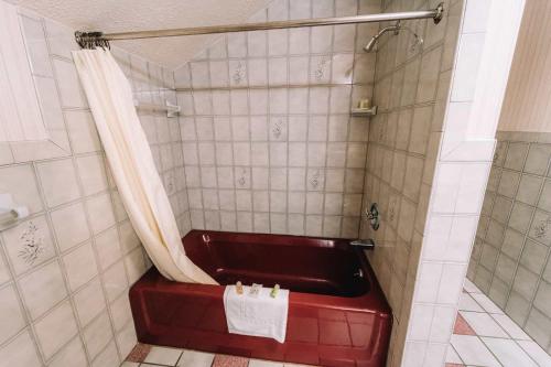 a shower with a red tub in a bathroom at Riverside Motor Lodge - Pigeon Forge in Pigeon Forge