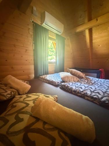 two beds in a room with a window at Bungalow Jajce 1 Cottage in Jezero