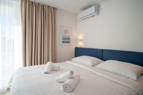 a bedroom with two towels on a bed at Alemaris Resort in Baška Voda