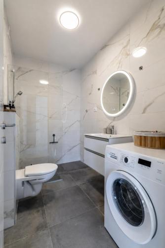 a white bathroom with a washing machine in it at Cocco & Limone Boutique Residence in Sutivan