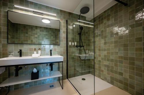 a bathroom with a sink and a shower with a mirror at Heritage Hotel Lucia in Dubrovnik