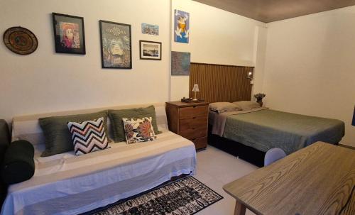 a hotel room with two beds and a table at Estúdio aconchegante com cozinha externa e quintal in Morro do Chapéu