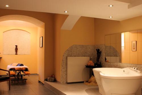 a bathroom with a tub and a sink and a mirror at Schlosshotel Ralswiek in Ralswiek