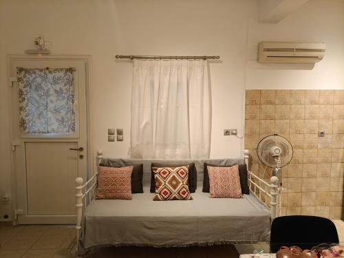 a bedroom with a bed with pillows and a window at Gorgona 1 in Loutra