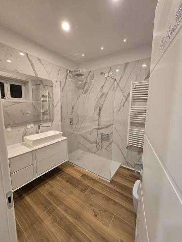 a white bathroom with a shower and a sink at Travel Baiot'S in Villanova di Farra