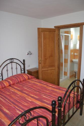 a bedroom with a bed with a red and orange blanket at B&b Gennargentu in Fonni