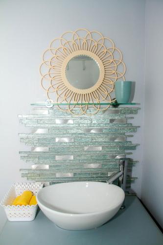 a mirror on a wall above a sink in a bathroom at Cote Cottage in Somerset West