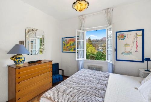 a bedroom with a bed and a dresser and a window at Casa Donata by Gottschalk in Lierna