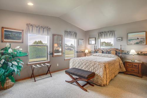 a bedroom with a bed and a chair and windows at Charming Sequim House w/ Olympic Peninsula Views! in Sequim