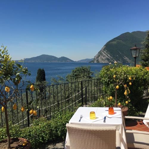 a table and chairs with a view of the water at Castello Oldofredi in Monte Isola